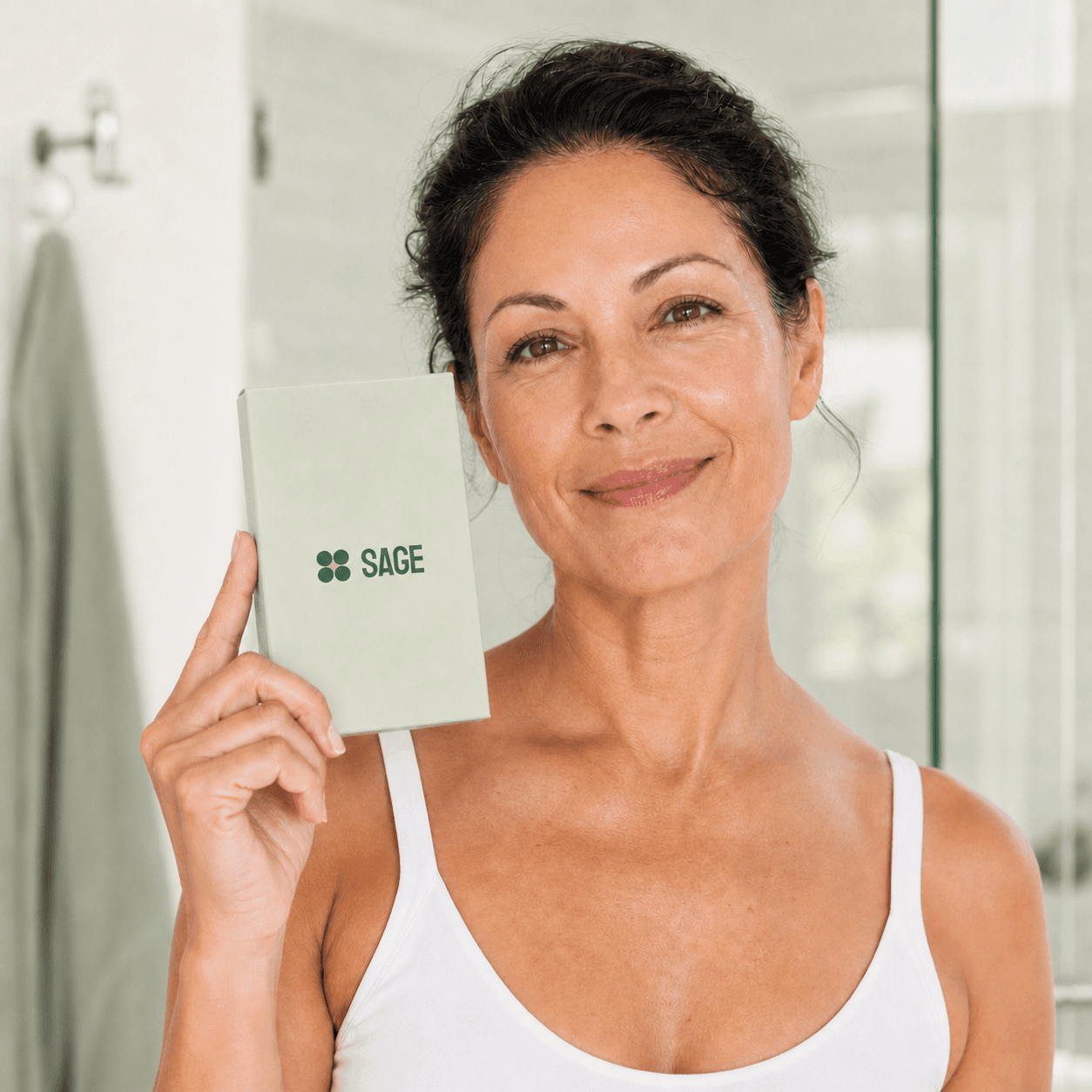 Sage Renewal customer holding the light sage-green product carton